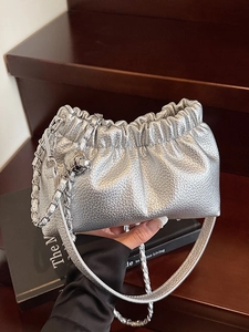 Borsa nuvola argento metallizzato con tracolla a catena e pieghe su legno