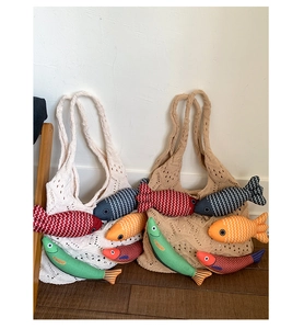 Detail of hand-woven knit tote bags featuring colorful fish-shaped decorative charms