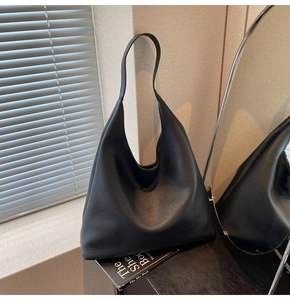Dettaglio della borsa tote in pelle nera a grana di litchi con pieghe morbide eleganti