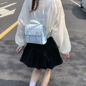 Close-up of light blue gingham backpack with dual buckles and adjustable straps