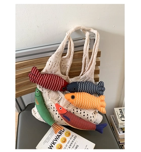 Close-up of colorful fish plush toys inside a cream hollow-out knit tote bag