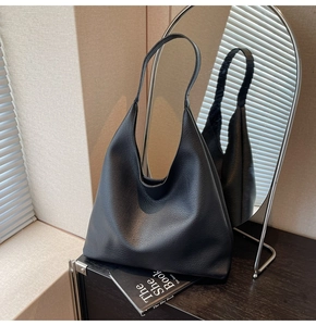 Dettaglio riflesso della borsa hobo nera in pelle a grana litchi con tracolla integrata