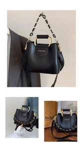 Detail of black bucket bag featuring metal handles and adjustable letter-print wide strap