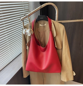 Dettaglio della borsa tote rossa in pelle a trama litchi appesa per lo stile urbano