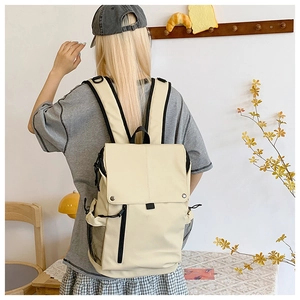 Vue détaillée du sac à dos crème de grande capacité avec zips noirs et bretelles rembourrées