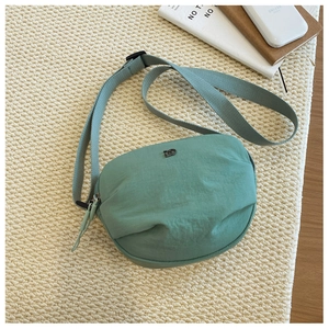 Detail of mint green crescent bag with pleated fabric and adjustable nylon strap