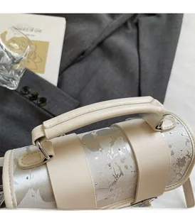 Détail de la poignée en cuir blanc cassé avec texture argentée et rivets argentés
