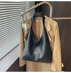 Dettaglio della borsa tote in pelle nera a grana con tracolla larga per uno stile urbano