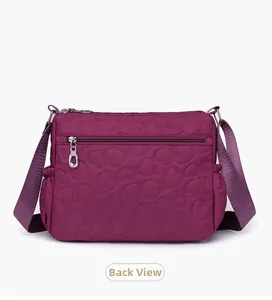 Rear view of purple nylon crossbody bag featuring heart quilting and metal zipper pocket