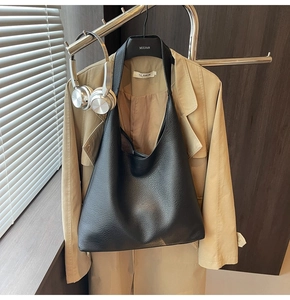 Dettaglio della texture in pelle nera su una grande borsa tote a spalla da donna