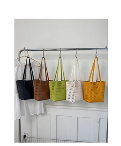 Detail of laser-cut geometric patterns on five colorful leather tote bags on a hanger