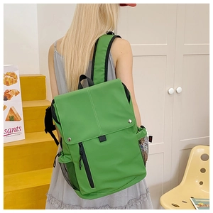 Détail du sac à dos en nylon vert herbe avec bretelles rembourrées et poche latérale filet