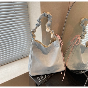 Détail du sac cabas marbré bleu clair avec anse plissée et breloque cordon rose