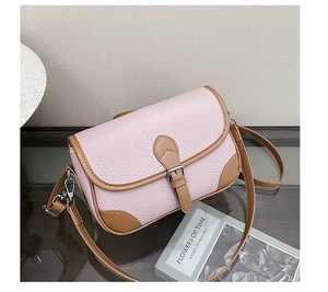 Detail view of pink lychee leather handbag with brown trim and silver buckle hardware
