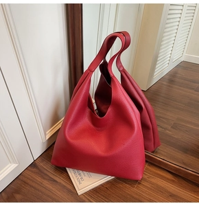 Dettaglio della grande borsa tote in pelle rossa con grana litchi riflessa nello specchio