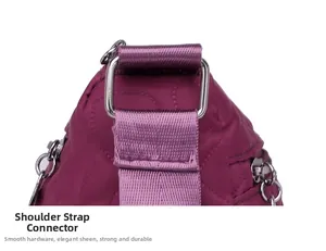 Detail of silver metal hardware and quilted nylon texture on the dark purple shoulder bag