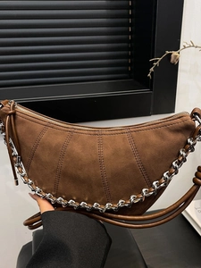 Chic brown suede crescent shoulder bag with metallic chain detail and stitched texture