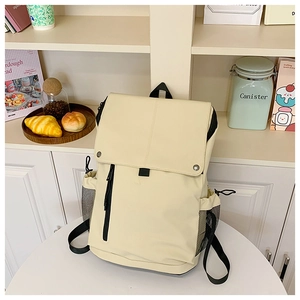 Vue détaillée du sac à dos en nylon crème avec fermetures éclair noires et poches latérales