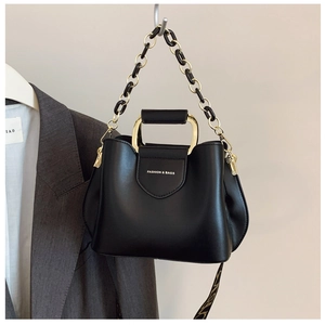 Detail of black leather bucket bag with gold chain strap and Fashion & Bags text