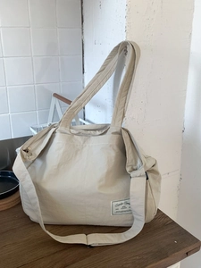 Large beige canvas tote bag with adjustable shoulder strap and double handles for daily use
