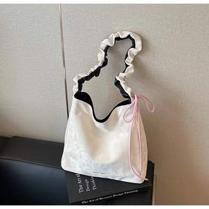 Détail du sac cabas plissé crème avec imprimé et cordon de serrage rose décoratif