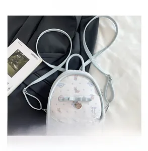 Gros plan d'un sac à dos blanc en cuir PU avec pois bleus, lapins et pendentif en cœur