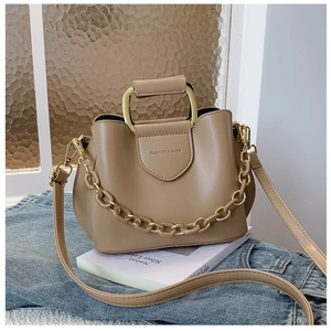 Detail of khaki PU leather bucket bag with gold chain and metal trapezoid handle