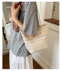 Detail of laser-cut geometric hollow pattern on cream tote bag with brand label