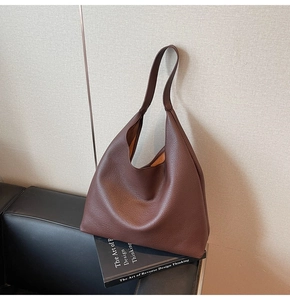 Macro della pelle marrone scuro con trama litchi su una borsa a tracolla stile vintage