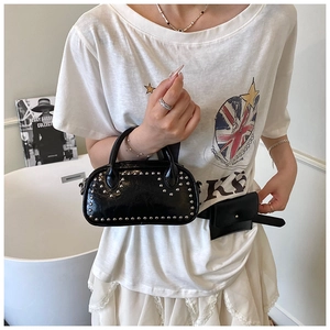 Detail view of glossy black PU leather handbag with silver rivets and matching belt bag