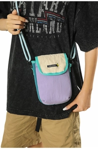 Detail of color-block nylon mini crossbody bag featuring purple, cream, and teal accents