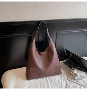 Dettaglio macro della borsa tote in pelle marrone scuro con grana litchi minimalista