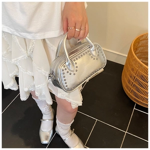 Detail shot of silver metallic leather handbag with decorative silver rivet studs