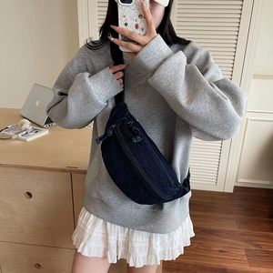 Mirror selfie showing the large capacity denim crossbody bag worn on a grey hoodie