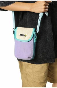 Detail of multi-color nylon crossbody bag with braided rope strap on model