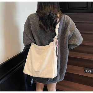 Détail du sac cabas blanc crème avec bandoulière plissée et cordon de serrage rose