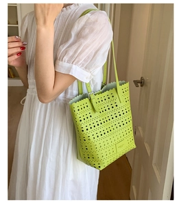 Detail of green hollowed tote bag featuring laser-cut patterns and wavy scallop edges