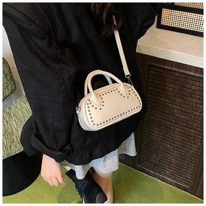 Detail view of cream leather Boston bag with metallic studs and detachable shoulder strap