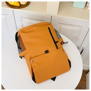 Détail d'un sac à dos en nylon imperméable jaune moutarde avec plusieurs poches