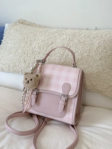 Pink plaid faux leather backpack with metallic buckles and a cute plush bear accessory