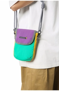 Close-up of a mini nylon crossbody bag in purple, mint green, and yellow on a model