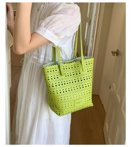 Detail of the green perforated geometric laser-cut pattern on the large tote bag