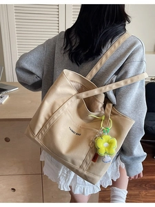Grande borsa tote in tela beige con doppia tracolla e ciondolo a fiore giallo