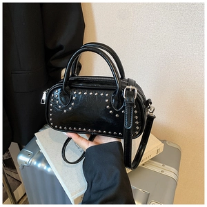 Detail of black riveted Boston bag in crinkled leather with silver studs and straps