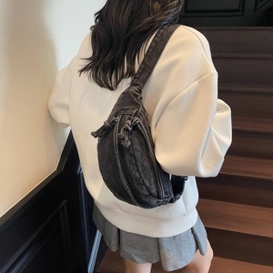 Detailed back view of dark grey denim chest bag with adjustable strap on model