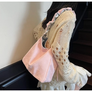 Gros plan d'un sac à bandoulière rose avec poignées plissées argentées métallisées stylisées