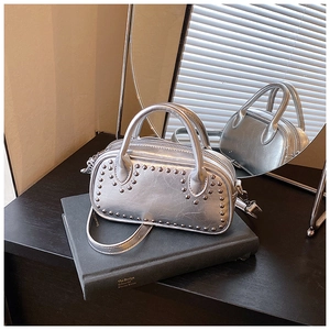 Detailed view of silver metallic rivet bag with wrinkled texture and stylish top handles