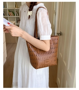 Detail view of brown faux leather tote with geometric laser-cut patterns and wave edges