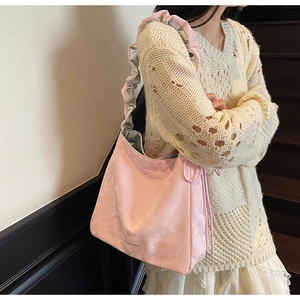 Détail du sac bandoulière plissé rose avec bandoulière à volants et cordon de serrage