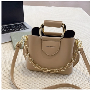 Detail of khaki bucket bag with gold metal U-handle on a cozy knit background